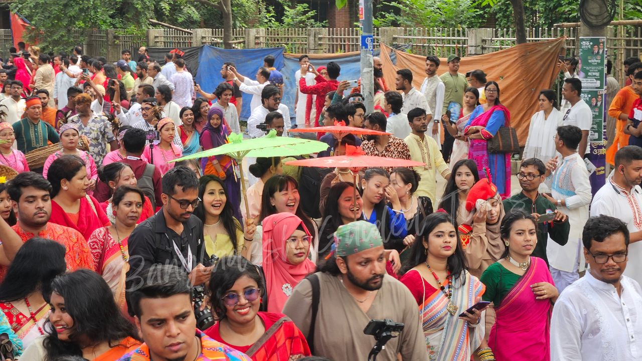 Chinese visitors celebrating Pohela Boishakh in Bangladesh during Mangal Shobhajatra with colorful cultural masks, traditional Bengali artwork, and festive New Year atmosphere — Bangladesh Guided Tours