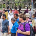 European visitors joining Pohela Boishakh Mangal Shobhajatra in Bangladesh with colorful masks, folk art, and Bengali New Year celebration — captured by Bangladesh Guided Tours