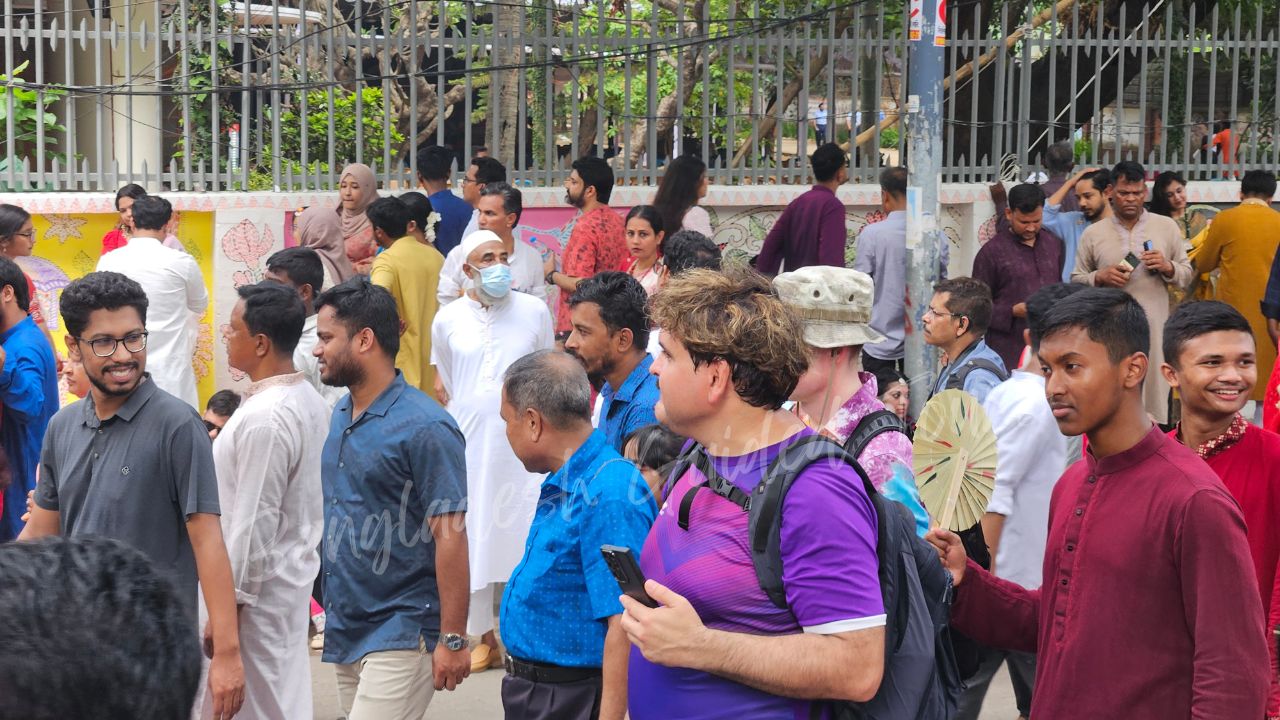 European visitors joining Pohela Boishakh Mangal Shobhajatra in Bangladesh with colorful masks, folk art, and Bengali New Year celebration — captured by Bangladesh Guided Tours