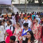 German tourists celebrating Pohela Boishakh in Bangladesh during the lively Mangal Shobhajatra with traditional masks, bright folk motifs, and New Year festivities — Bangladesh Guided Tours