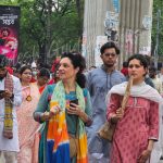 North American visitors joining Pohela Boishakh Mangal Shobhajatra in Bangladesh with colorful masks, folk art, and Bengali New Year celebration — captured by Bangladesh Guided Tours