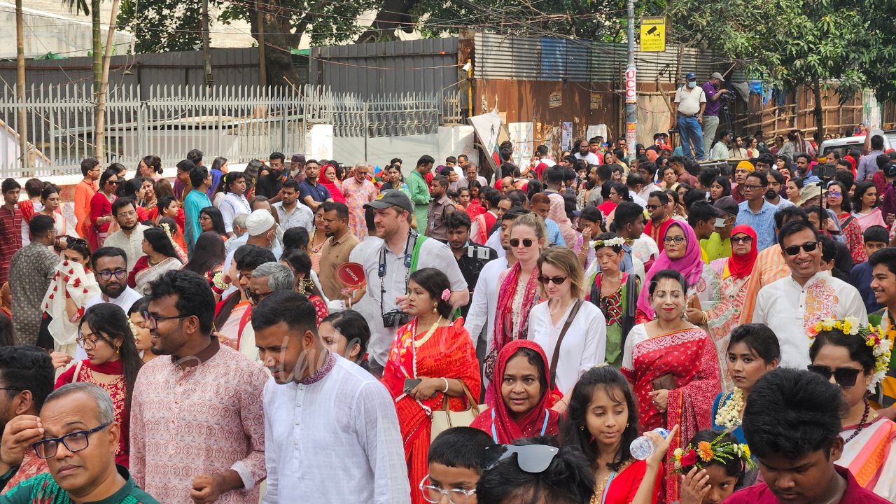 Polish visitors taking part in Pohela Boishakh Mangal Shobhajatra in Bangladesh amid colorful traditional masks, folk designs, and Bengali New Year celebrations — Bangladesh Guided Tours
