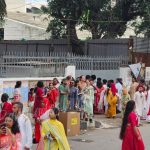 Russian visitors participating in Pohela Boishakh Mangal Shobhajatra in Bangladesh surrounded by vibrant masks, folk art displays, and Bengali New Year cultural festivities — Bangladesh Guided Tours