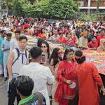 South Korean visitors enjoying Pohela Boishakh Mangal Shobhajatra in Bangladesh with vibrant cultural masks, traditional folk art, and lively Bengali New Year celebration — Bangladesh Guided Tours