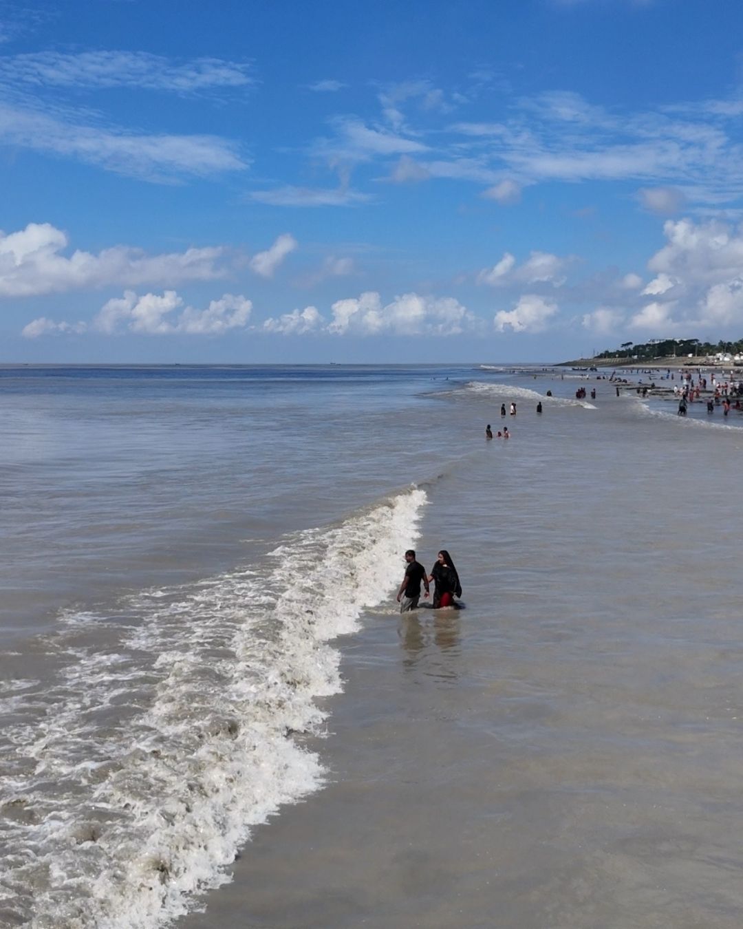 Endless shoreline of Cox’s Bazar sea beach under golden sunset sky