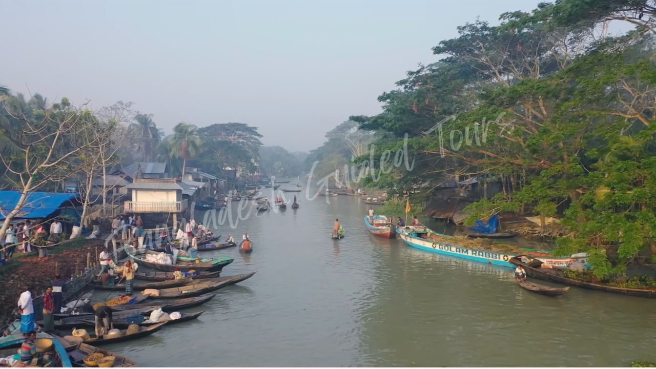 Local traders selling goods from wooden boats in floating market Bangladesh