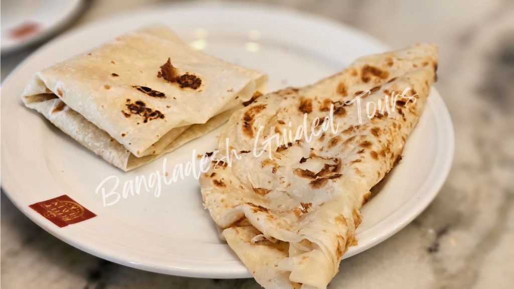 Traditional Rumali Ruti (thin handkerchief bread) and flaky Porota served with curry in Old Dhaka, Bangladesh street food for foreign tourists