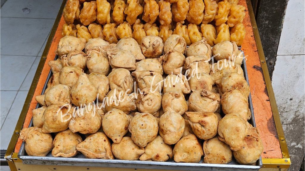 Hot crispy Shingara (Bangladeshi samosa) served in Old Dhaka street stall, filled with spicy potato, peas, and traditional snacks for foreign tourists